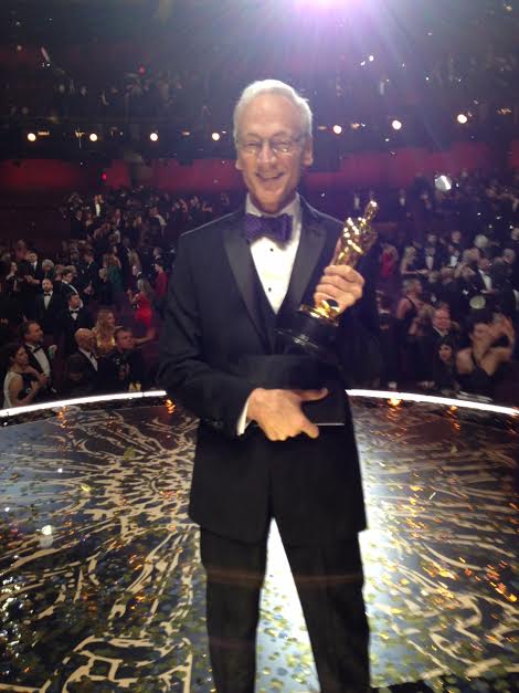 A man in a suit and tie holding an award.